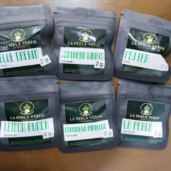 pack de 6 bolsas de flores de cbd de la perla verde cbd de 2 gramos cada una sobre un fondo de madera